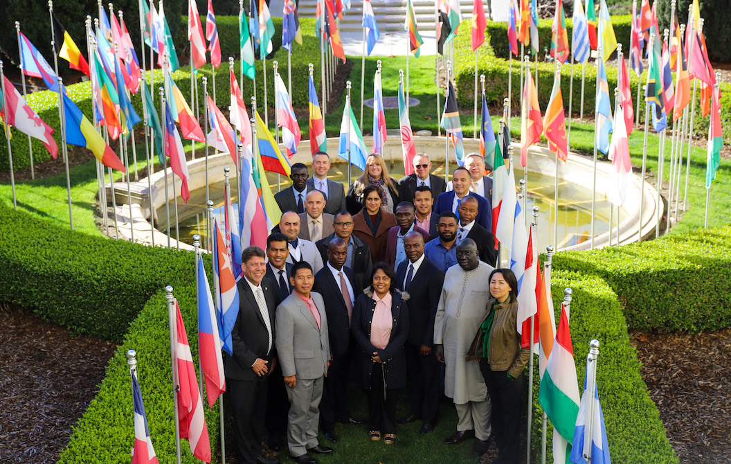 picture of a group standing in a garden with world flags