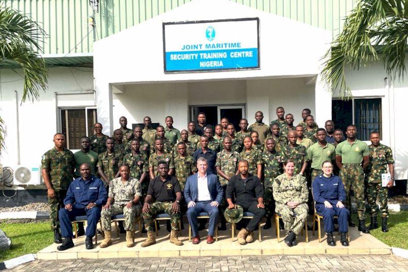 group of people standing in front of a white building
